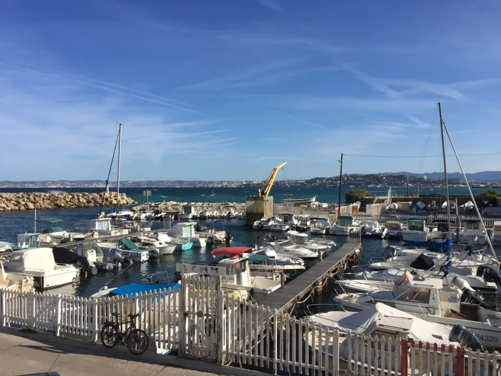 Vue du port de la Madrague avec des bateaux amarrés et un ciel ensoleillé