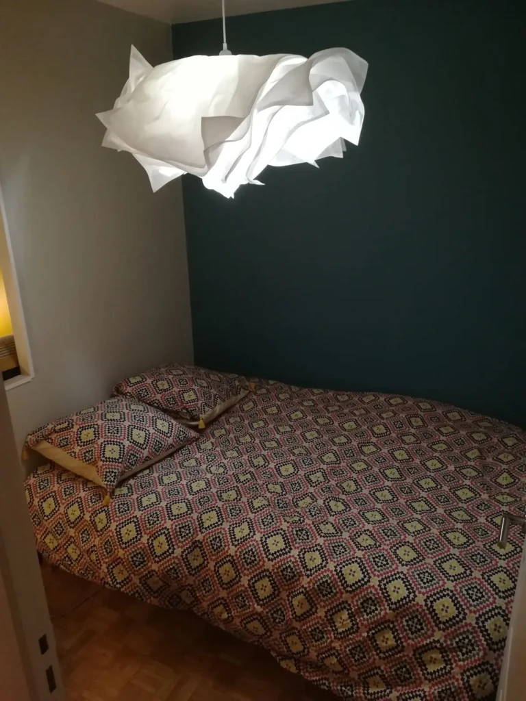 Chambre à coucher d'un appartement calme avec vue dégagée à Lyon, équipée d'un lit double et d'une décoration moderne.