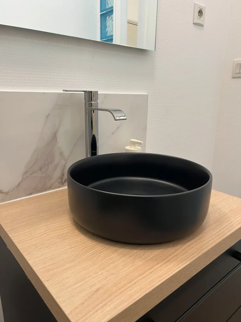 Lavabo moderne en noir sur plan en bois dans un appartement toulousain