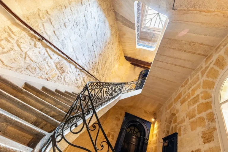 Escalier ancien avec balustrade en fer forgé dans un immeuble historique à Bordeaux, quartier Saint Pierre.