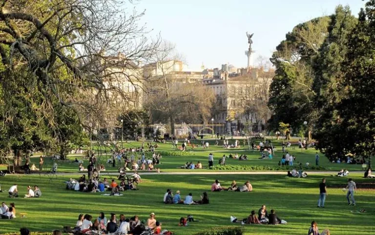 Vue du parc animé dans le quartier des Chartrons à Bordeaux, avec des personnes profitant du soleil sur l'herbe.