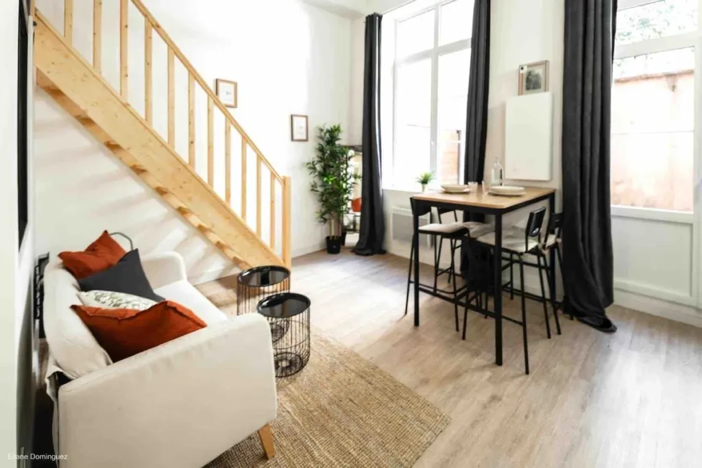 Salon lumineux avec coin repas et escalier en bois dans un appartement à Croix Rousse/Terreaux, Lyon