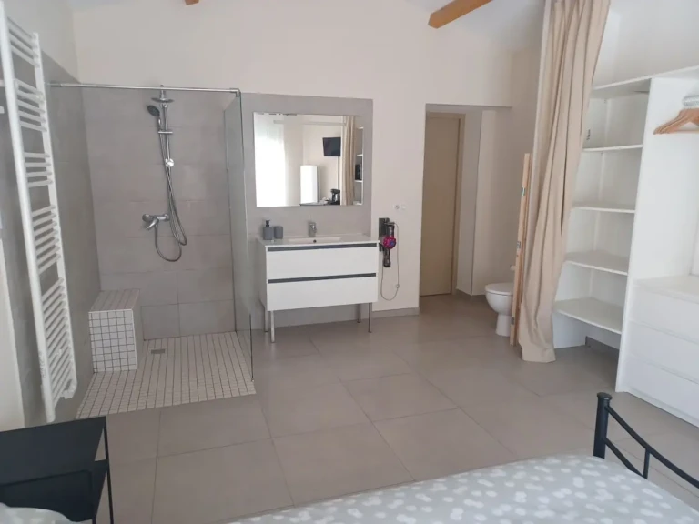 Salle de bain moderne dans une chambre chez l'habitant à Marseille, avec douche à l'italienne, lavabo et toilettes privatives.