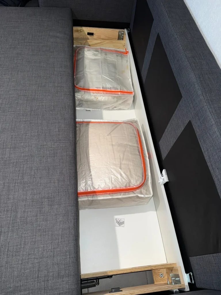 Espace de rangement sous un canapé-lit dans un appartement moderne à Marseille
