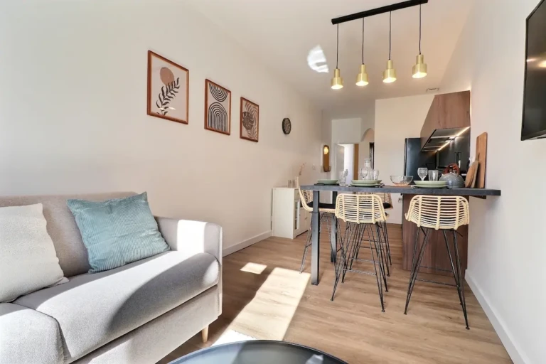 Intérieur d'un T2 de charme dans le quartier Part-Dieu, Lyon, avec salon accueillant et cuisine moderne.