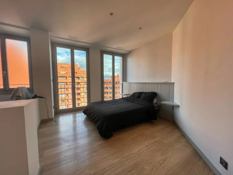 Chambre moderne avec vue sur les toits de Toulouse dans un penthouse