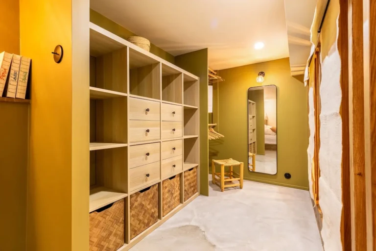 Intérieur du studio rénové avec rangement en bois et miroir.