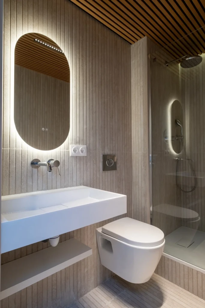 Salle de bain élégante et moderne dans un T2 à Toulouse, avec un éclairage doux et des matériaux haut de gamme.