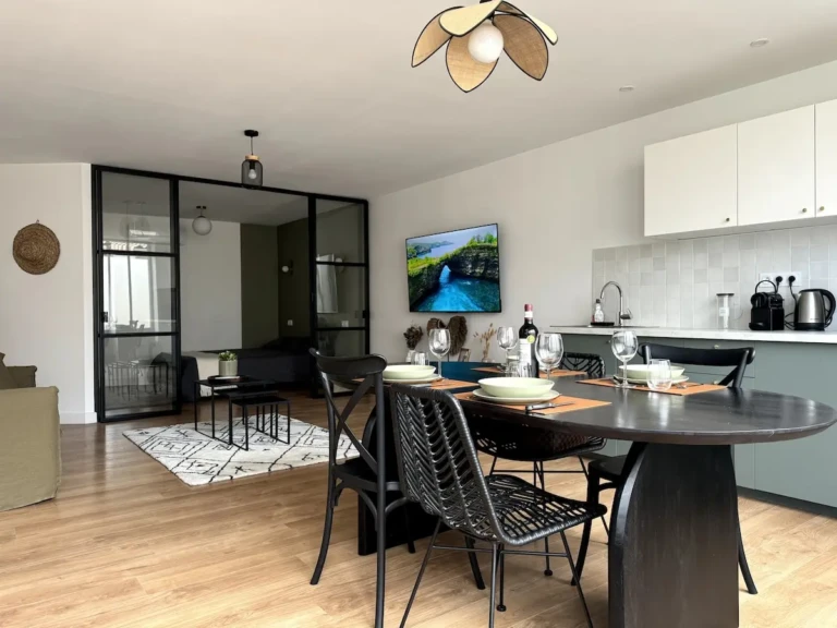 Vue intérieure moderne de l'appartement Casa Burdigala à Bordeaux, mettant en avant l'espace repas et le coin salon.