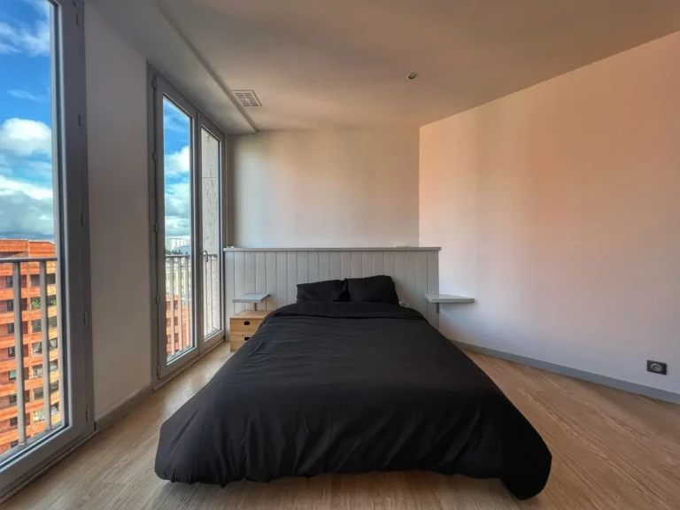 Chambre lumineuse avec vue panoramique sur Toulouse dans un penthouse
