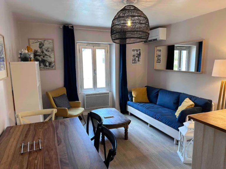 Salon lumineux d'un charmant T2 climatisé à Marseille, avec canapé confortable et table à manger.