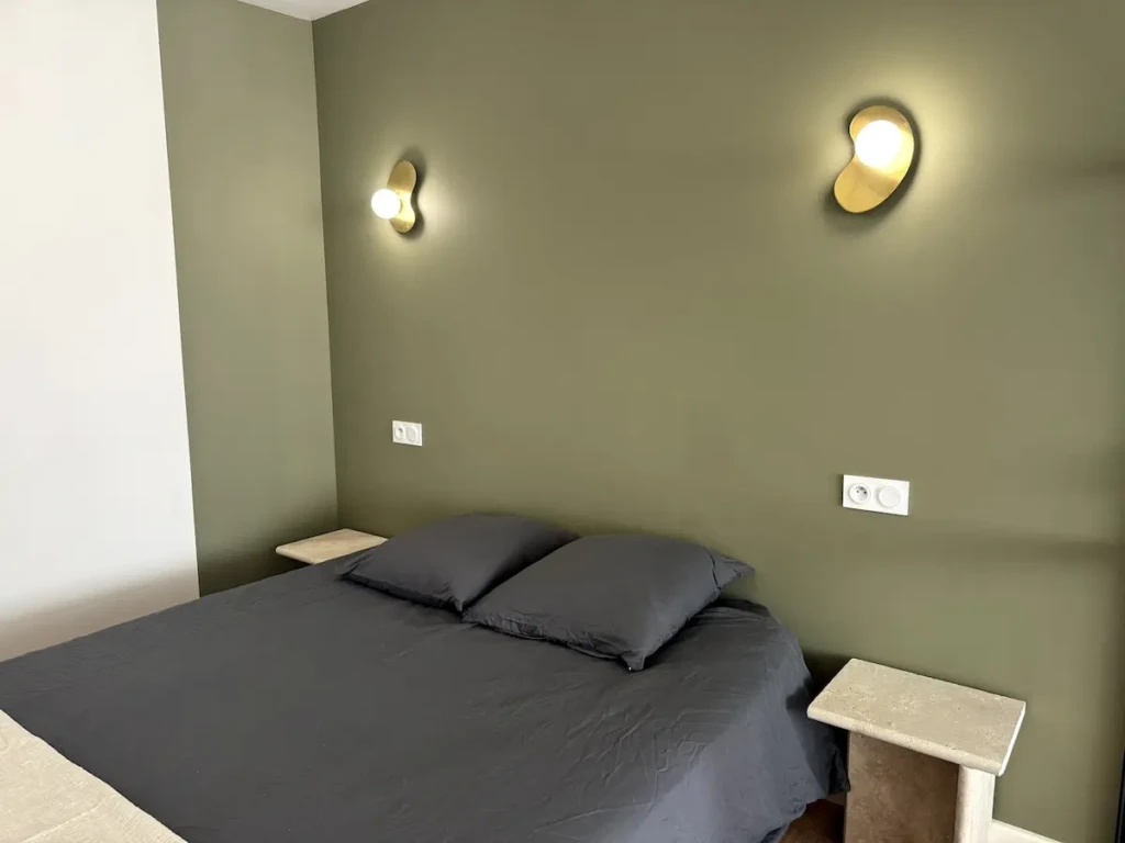 Chambre moderne avec lit double et éclairage chaleureux à Casa Burdigala, Bordeaux