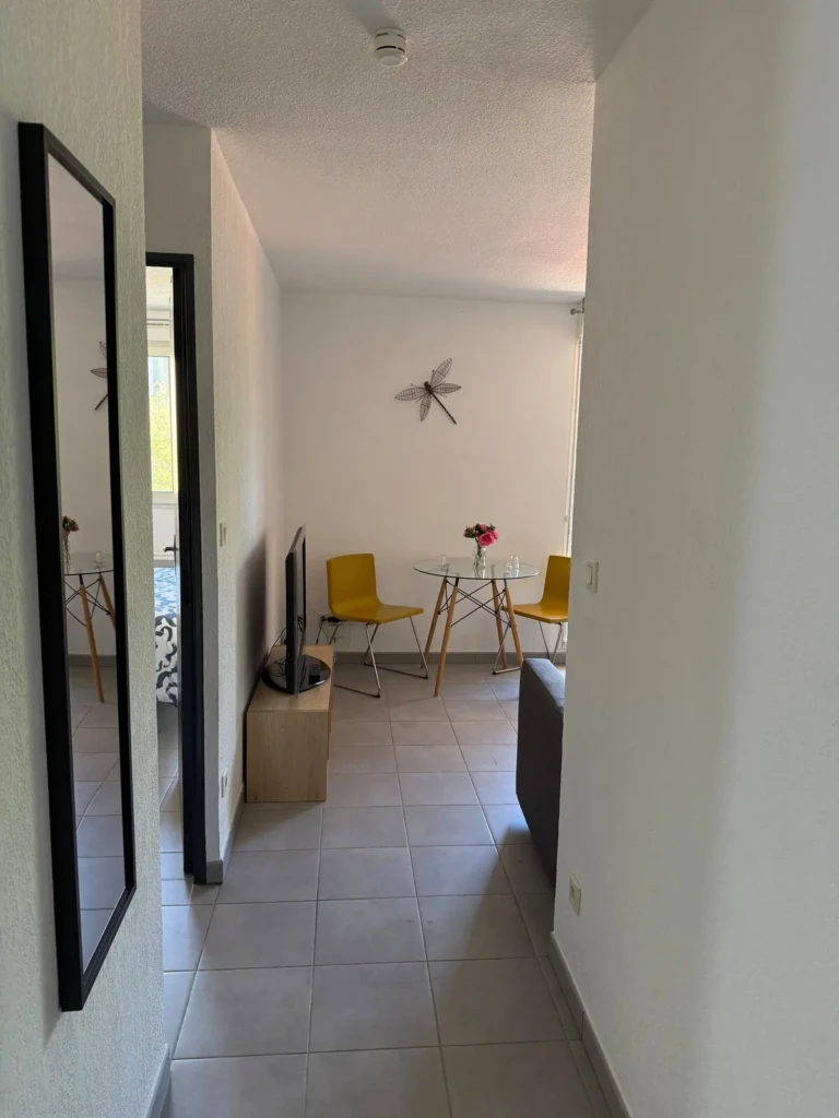 Vue intérieure d'un charmant T2 moderne à Marseille avec un décor lumineux et accueillant, mettant en avant la cuisine et la salle à manger.