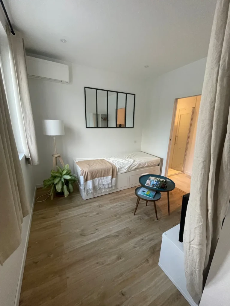 Intérieur lumineux et moderne d'un studio à Bordeaux avec climatisation et décor épuré.