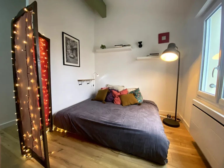 Chambre cozy avec éclairage chaleureux et mobilier moderne à Toulouse