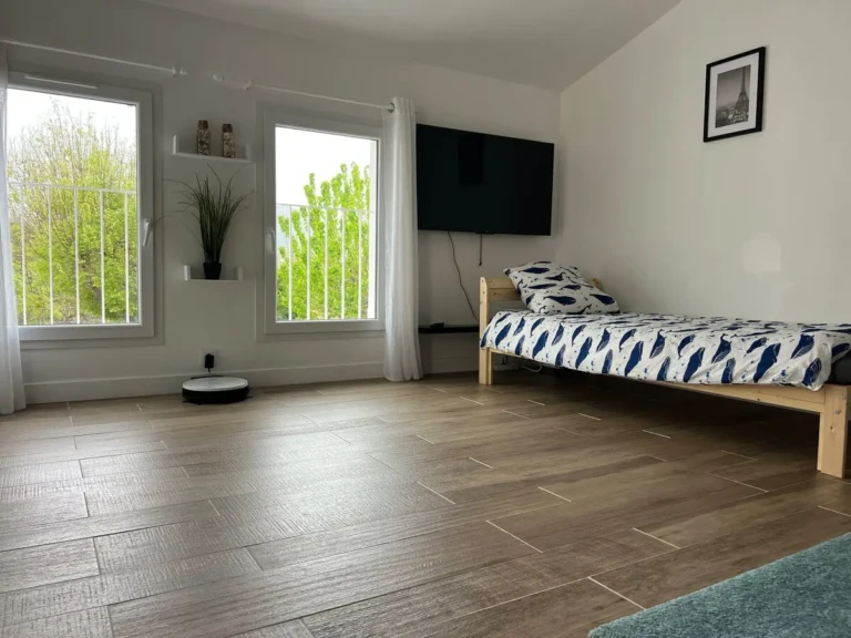 Studio indépendant lumineux avec lit simple et canapé-lit dans un cadre paisible