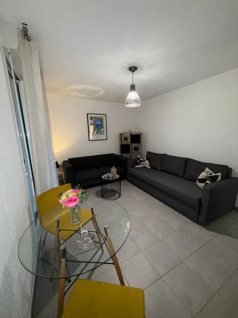 Salon lumineux d'un appartement moderne à Marseille avec canapé et table à manger