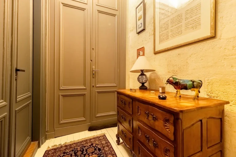Intérieur du studio Chez Louise, entrée avec meubles en bois et décoration élégante à Bordeaux.