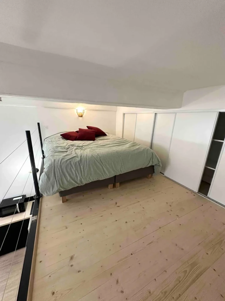 Chambre avec lit confortable et décor minimaliste à Lyon
