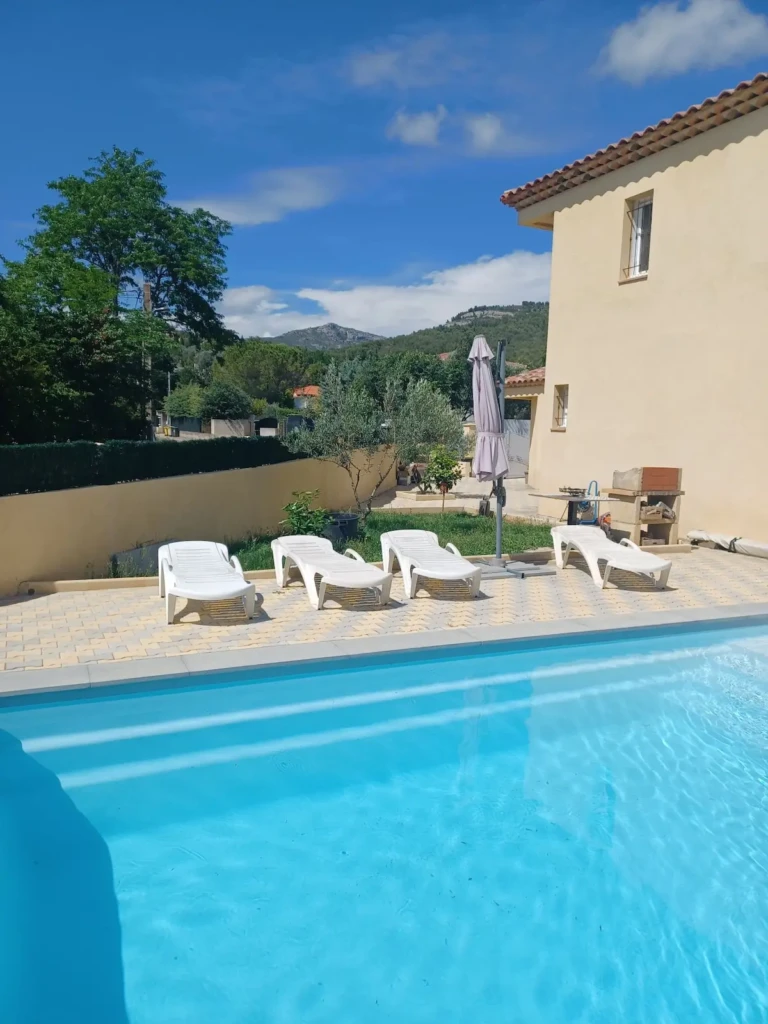 Piscine avec chaises longues dans une arrière-cour partagée à Marseille La Treille