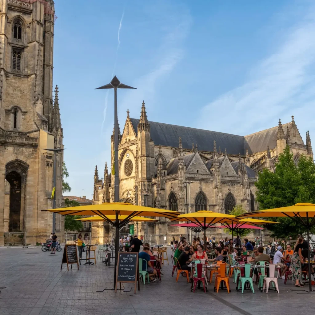 Vue sur la Basilique Saint Michel et une terrasse animée à Bordeaux Saint Michel