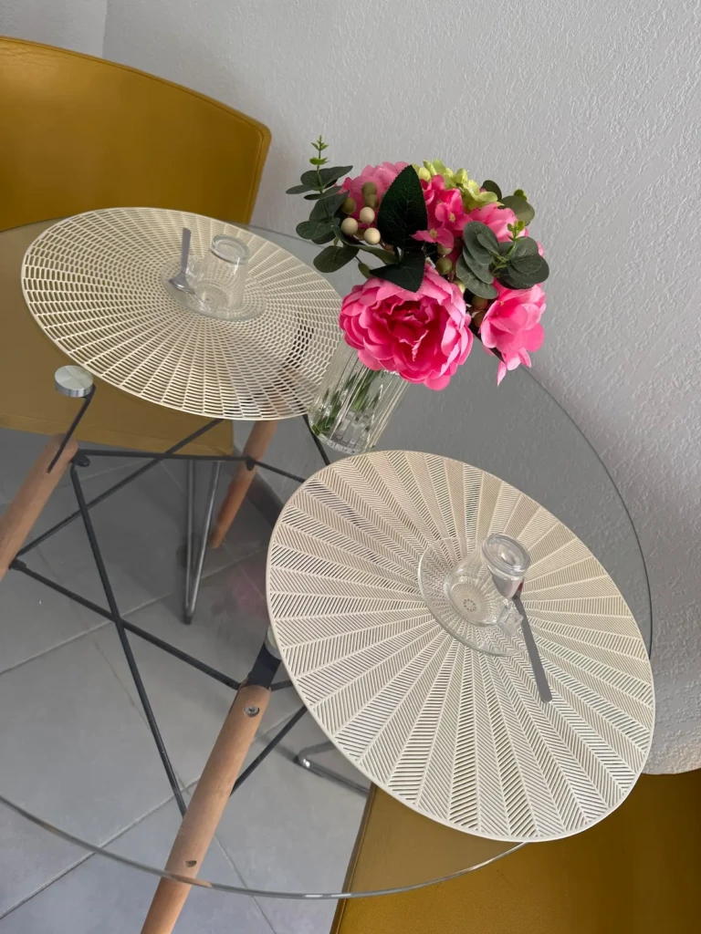 Une table avec des fleurs et un verre sur un fond moderne