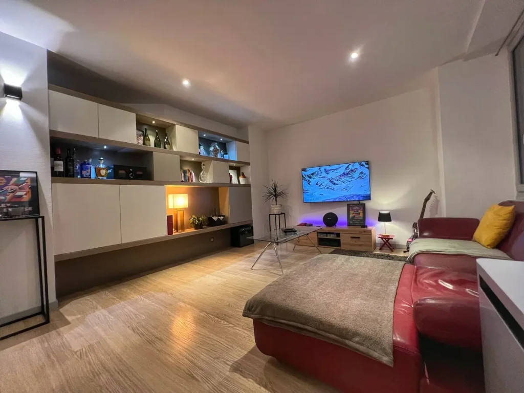 Intérieur moderne d'un loft avec un grand canapé et une télévision dans un salon lumineux à Toulouse, quartier Jean-Jaurès.