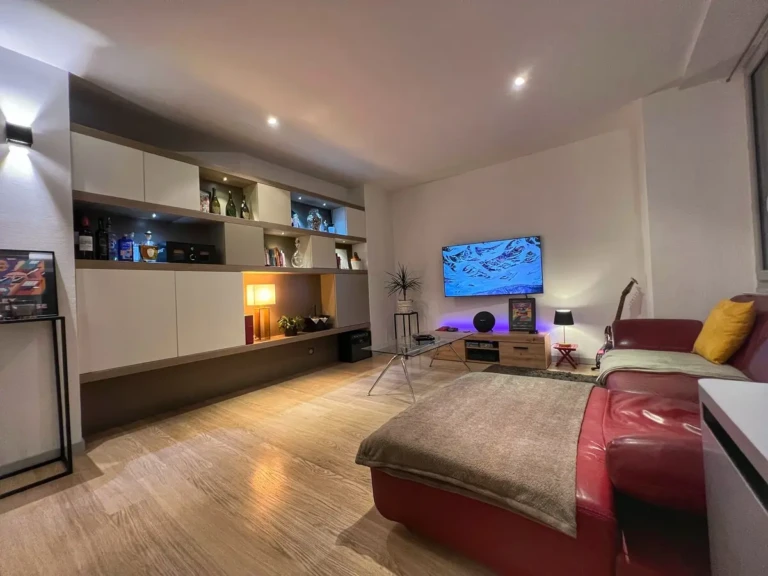 Intérieur moderne d'un loft avec un grand canapé et une télévision dans un salon lumineux à Toulouse, quartier Jean-Jaurès.