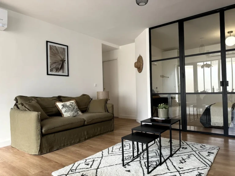 Salon confortable de l'appartement Casa Burdigala avec un canapé en lin et des éléments décoratifs modernes